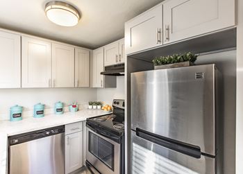 a kitchen with stainless steel appliances and white cabinets  at The Lakes Apartments, Moses Lake, WA